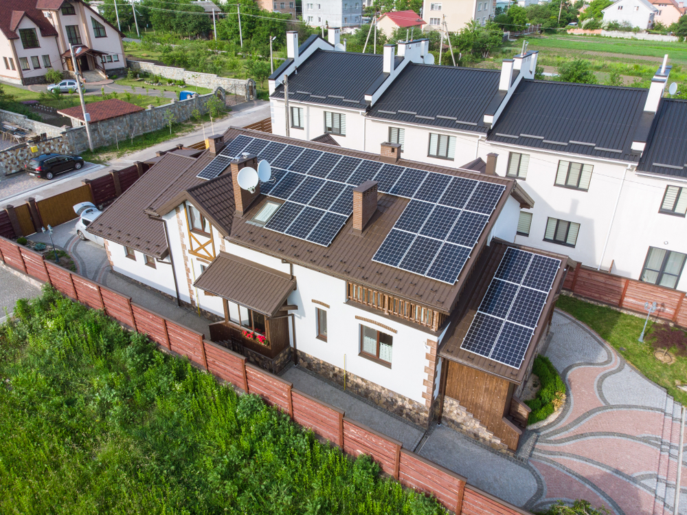 Aerial view of residential home with rooftop solar panel installation - Solar Energy Assistant helps homeowners maximize solar investment returns